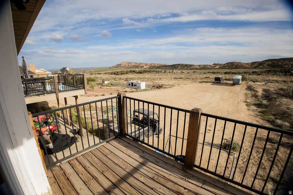Wood-finish decking with black metal railings, overlooking an expansive arid landscape