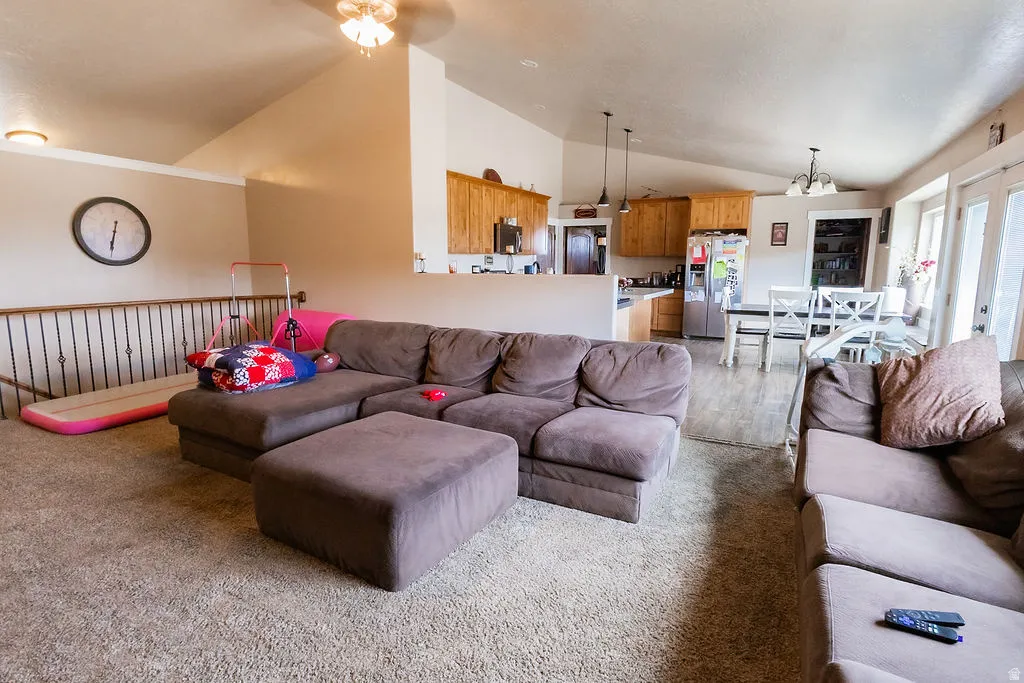 Vaulted ceilings enhance this open-concept living area with plush carpeting