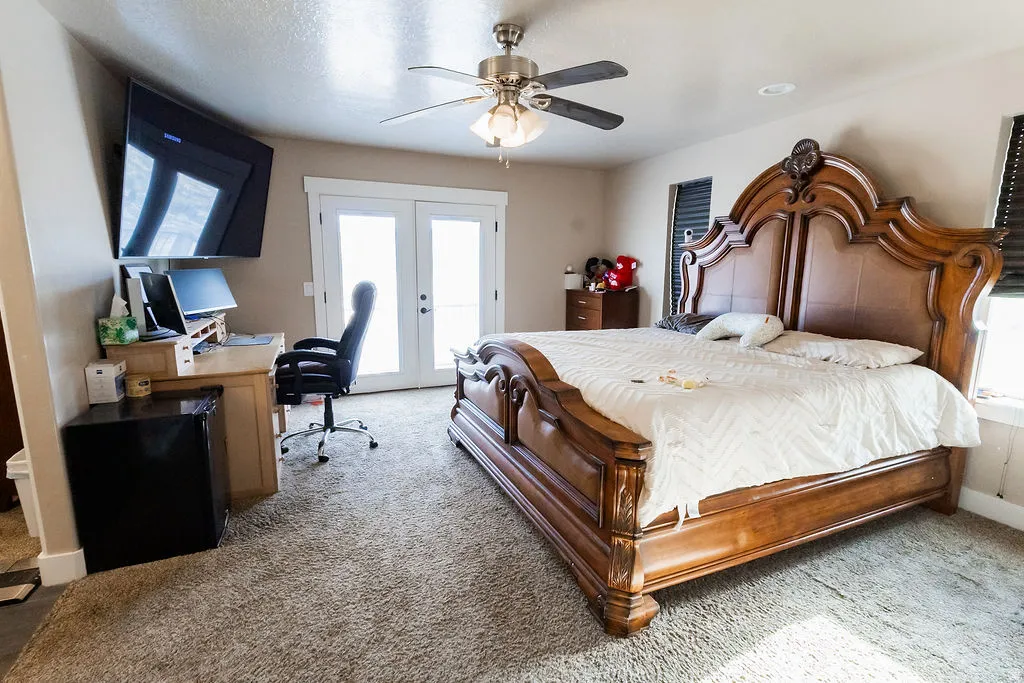 Bedroom with carpet flooring, ceiling fan, and French doors