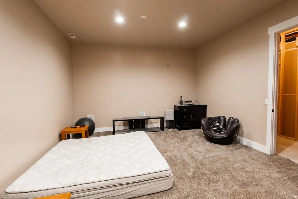 Spacious room with plush carpet flooring, neutral-toned walls, and recessed lighting