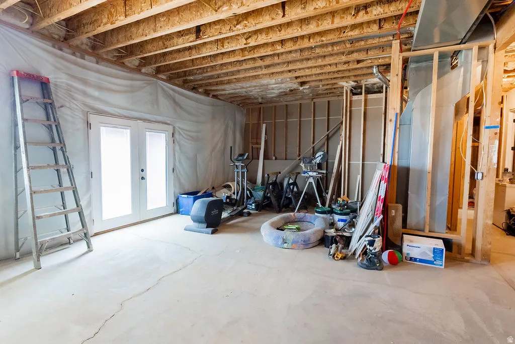 Unfinished basement with exposed ceiling joists and concrete flooring