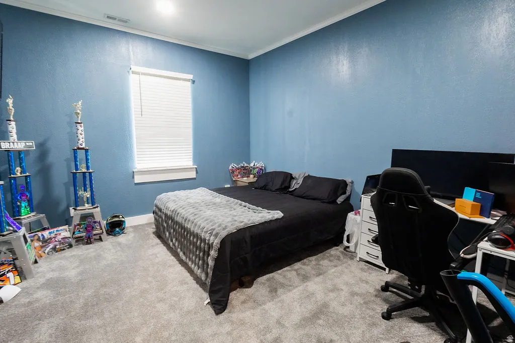 Bedroom with light blue walls, white window trim, and a horizontal window blind