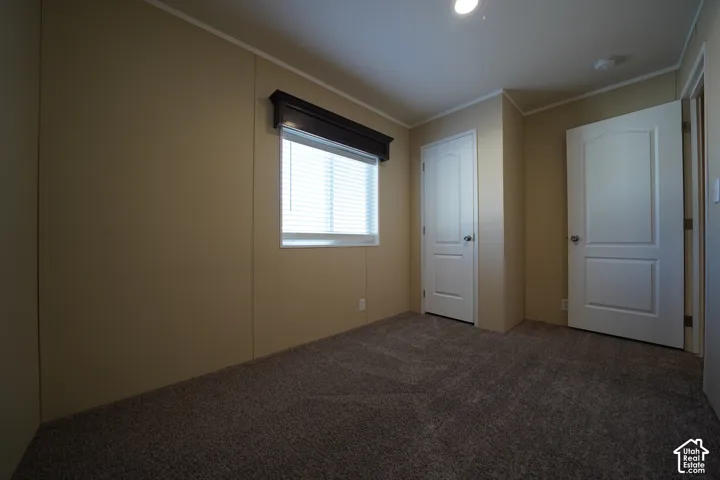 Bedroom 3 - Interior room featuring neutral wall paneling, textured carpet flooring, and white trim