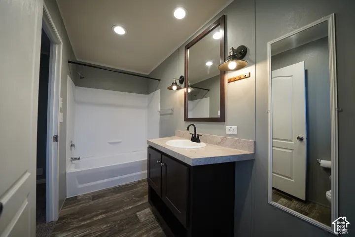 Primary Bathroom featuring a dark wood-finish vanity with a light-toned countertop and an integrated sink