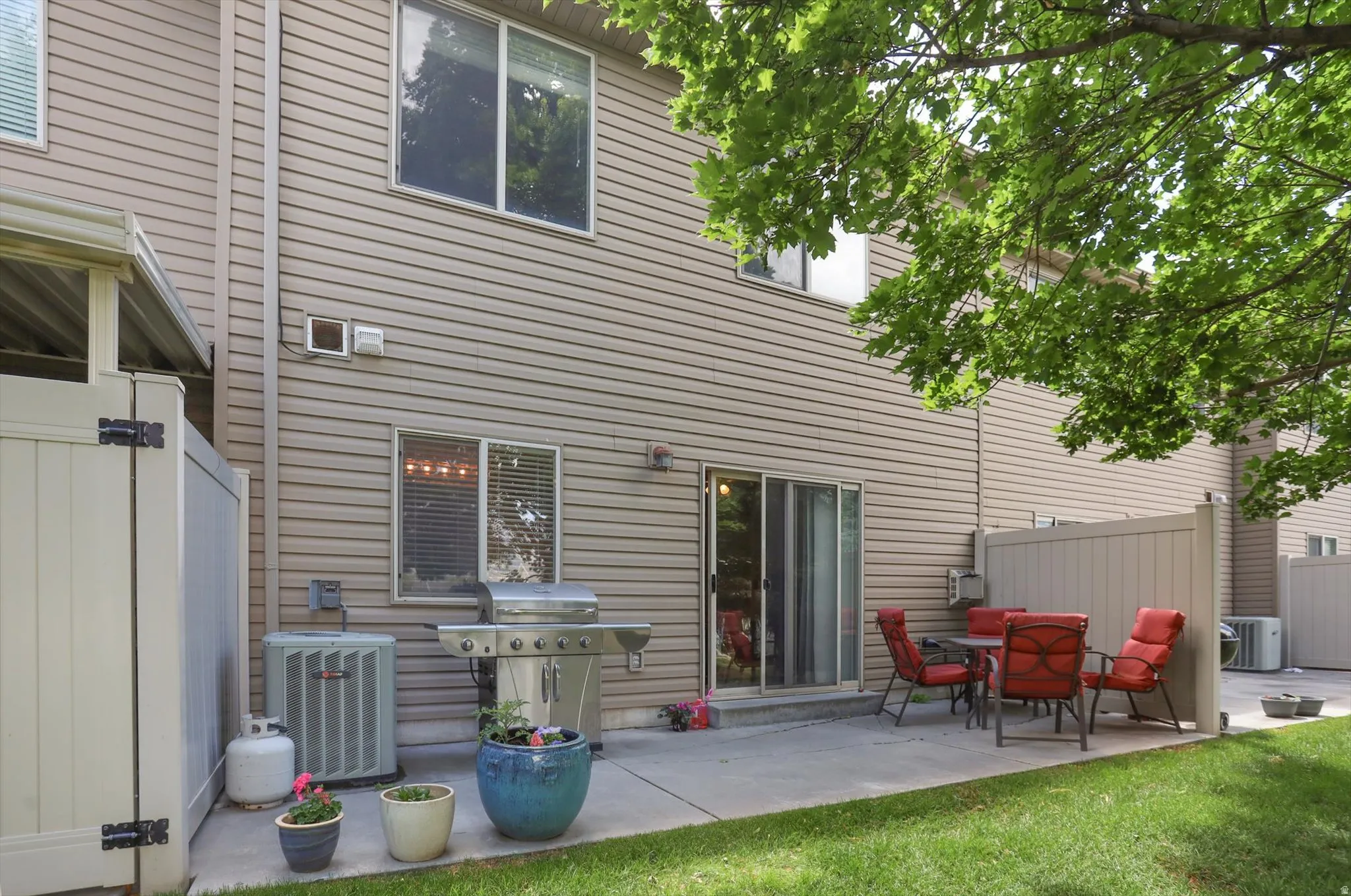Private patio space featuring a concrete pad, sliding glass door access, and a partial privacy fence