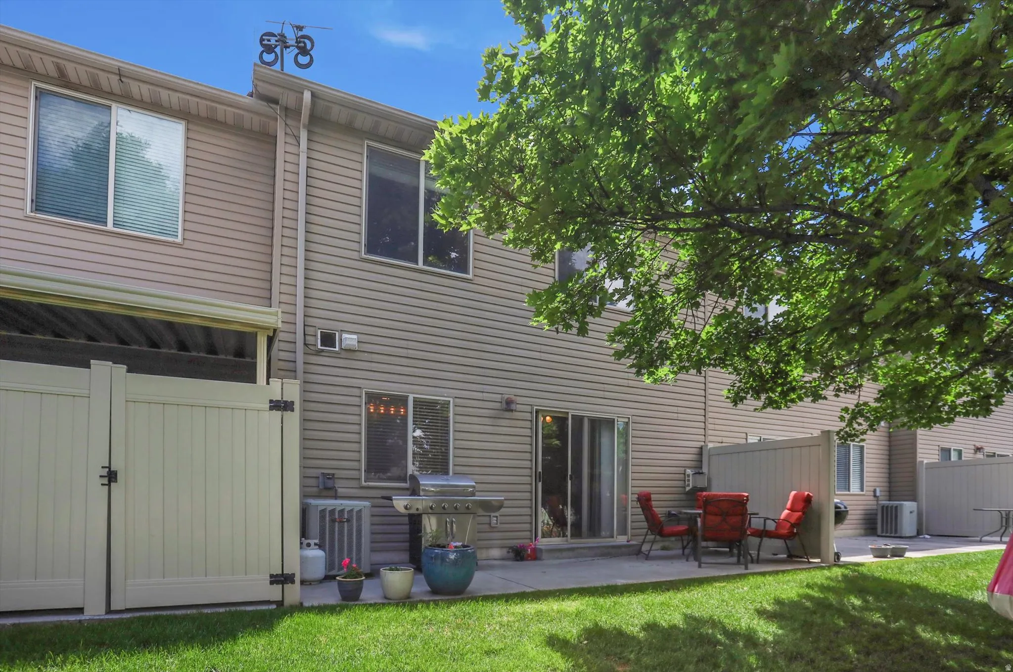 Private outdoor patio with a concrete surface, enclosed by a light-toned privacy fence