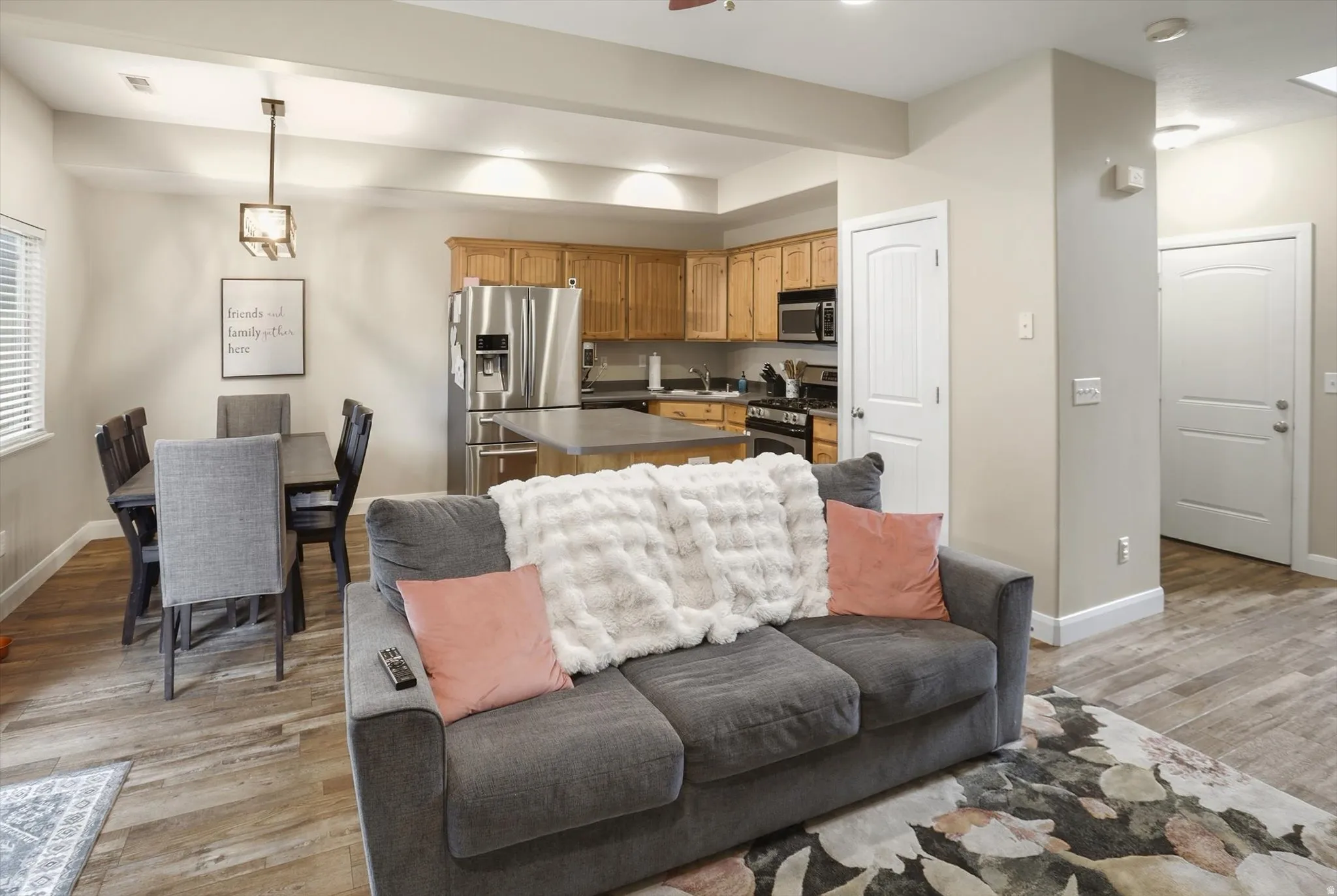 Open-concept living area featuring wood-finish flooring, recessed lighting, and a neutral wall palette