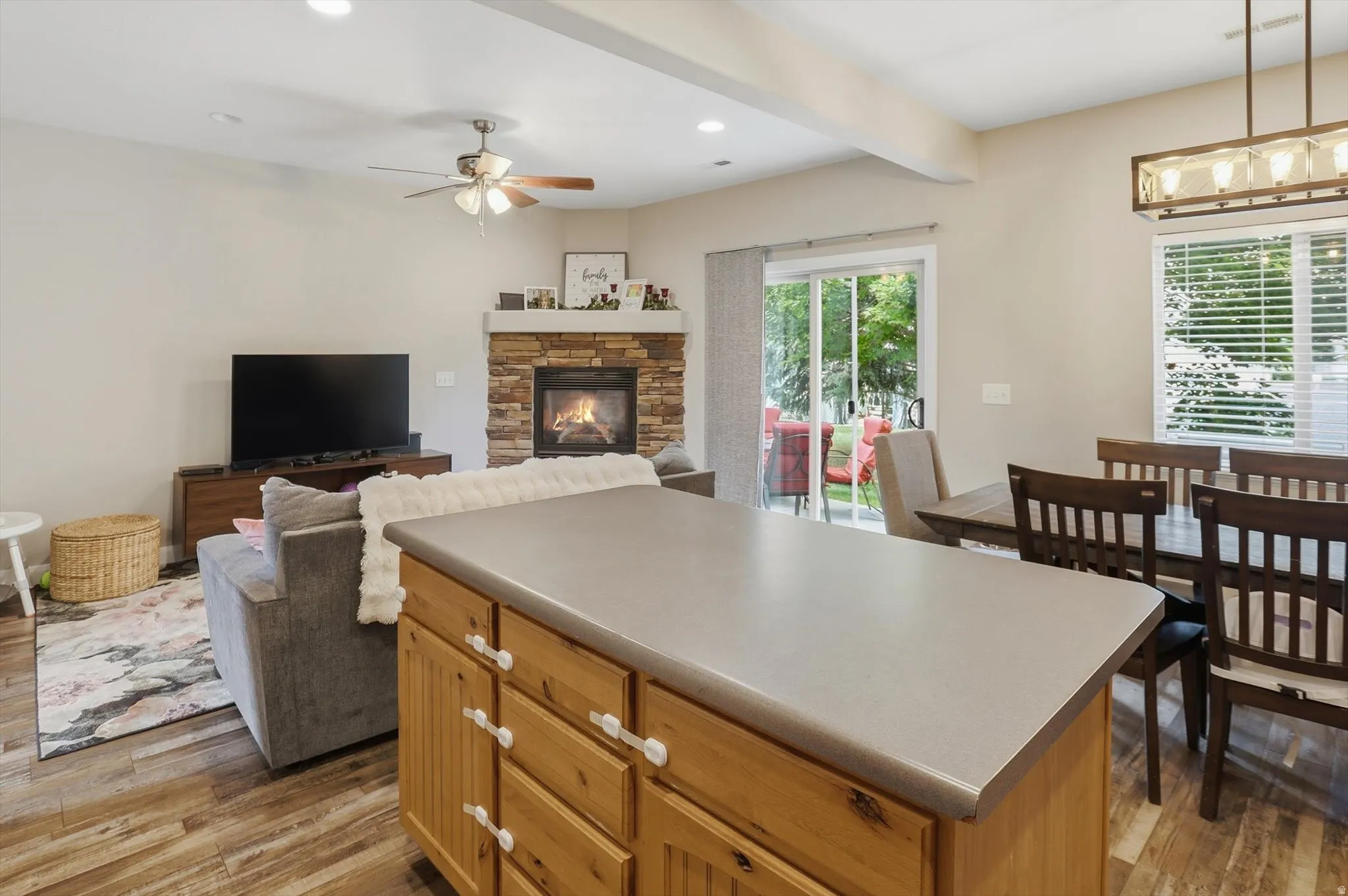Kitchen island with light wood cabinetry and a solid surface countertop
