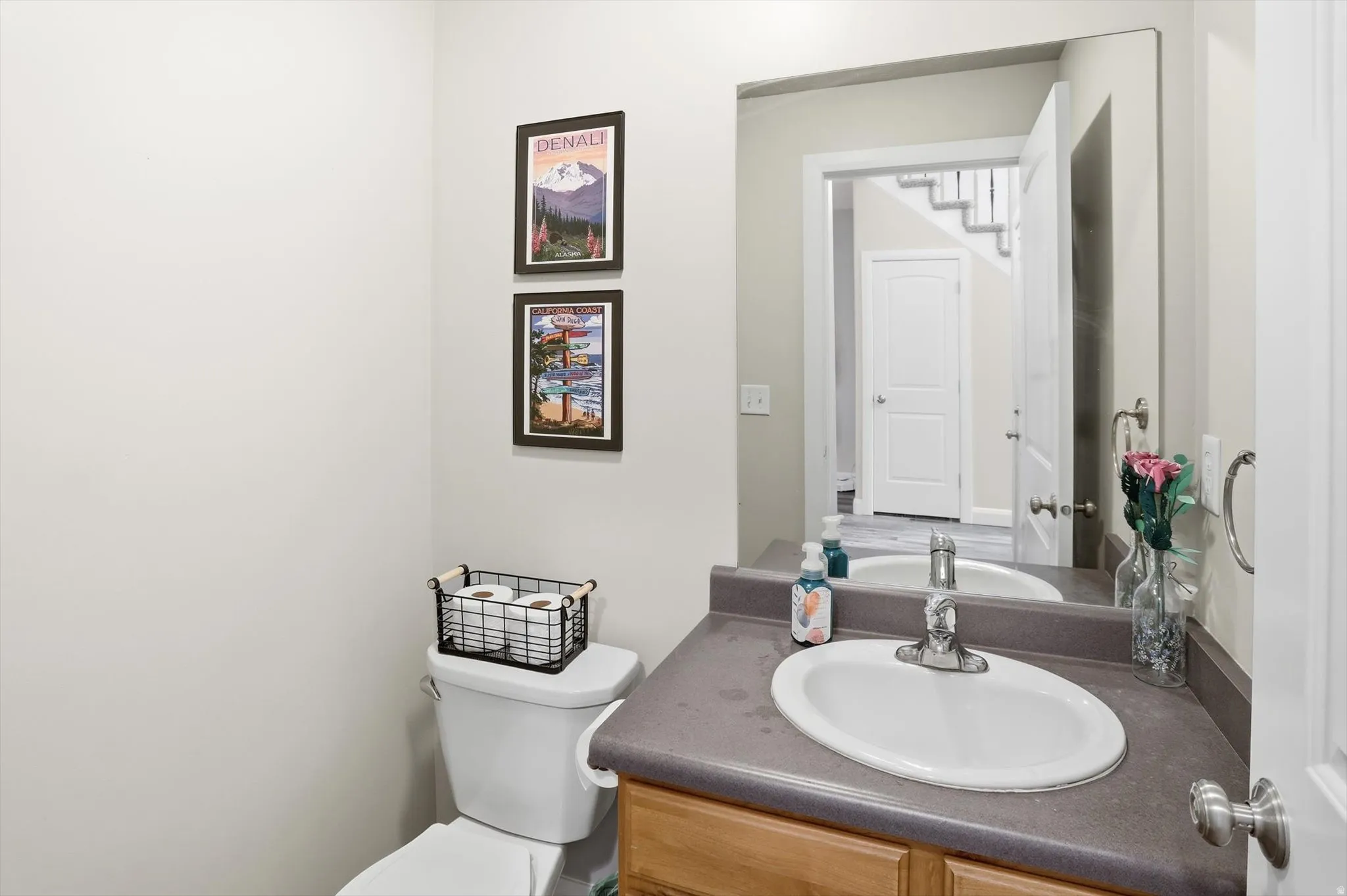 Bathroom vanity featuring an oval sink with chrome faucet, a stone-finish countertop, and wood-finish cabinetry