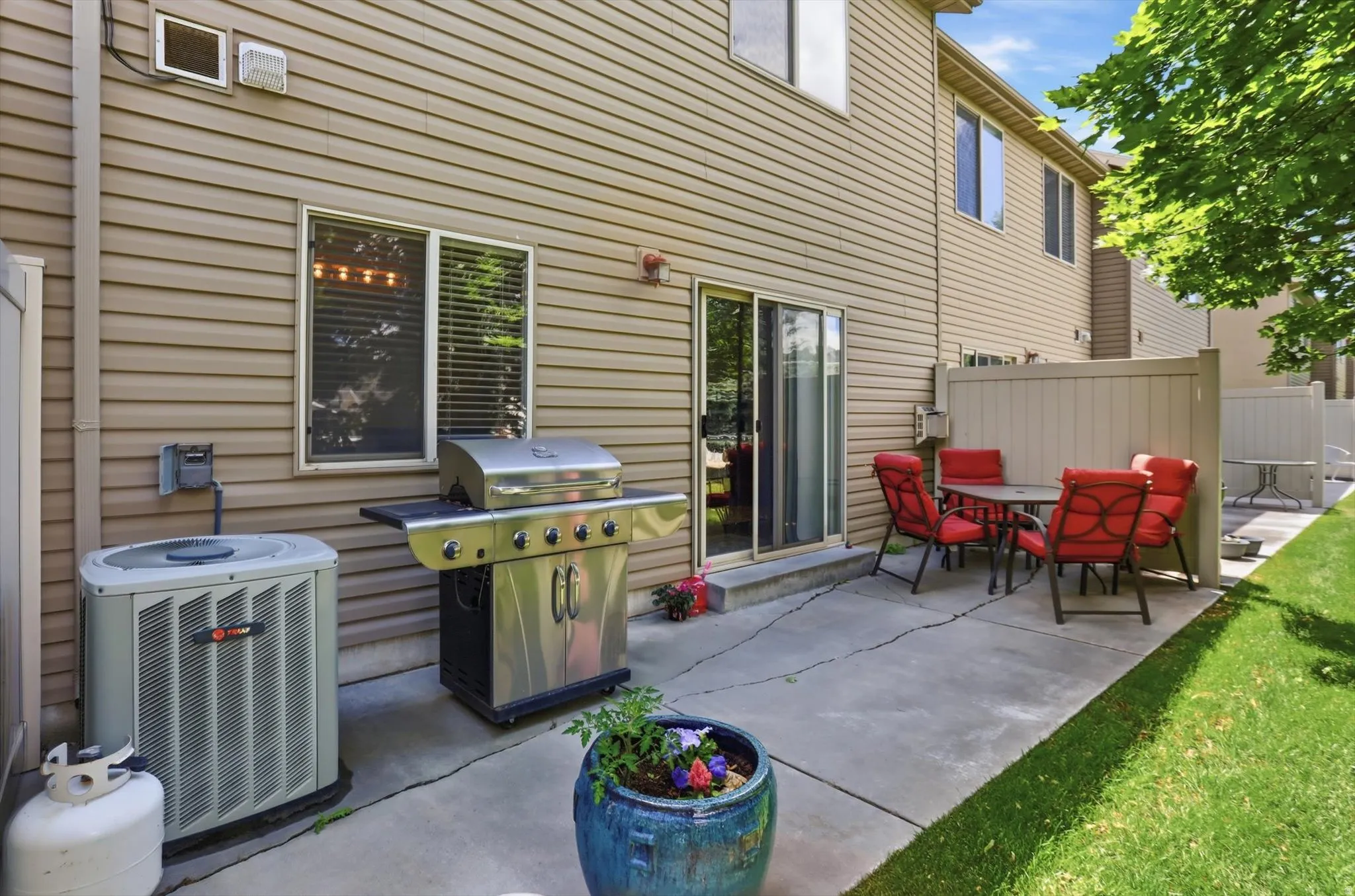 Patio area featuring a sliding glass door entry, concrete hardscaping, and a privacy fence
