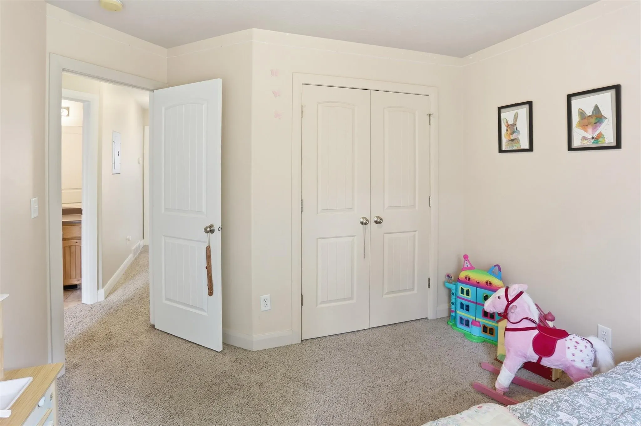 Carpeted room featuring a double-door closet, painted trim, and a paneled interior door