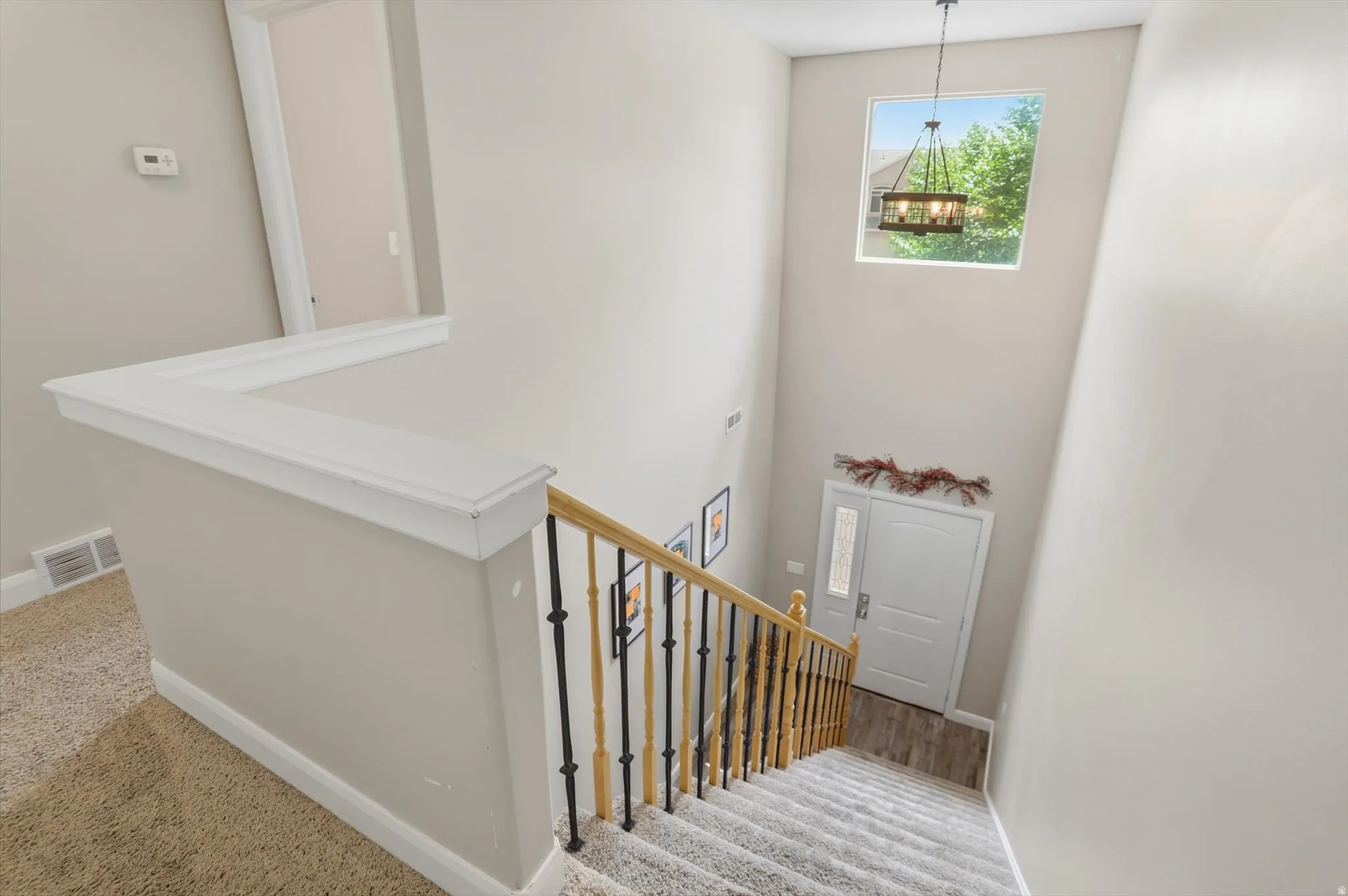 Two-story entryway with a transom window and a contemporary chandelier