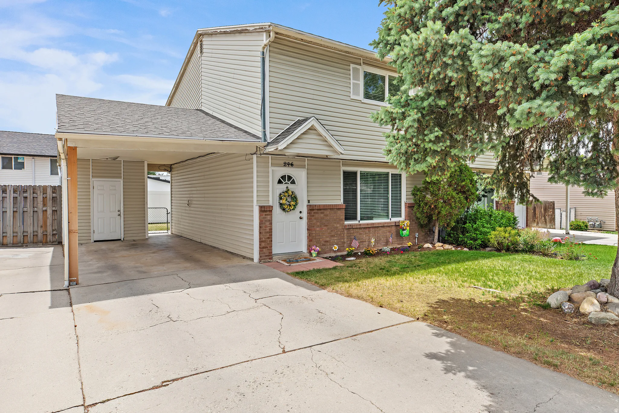 Two-story property featuring siding and brick accents, a covered carport, and a front entry with a small porch