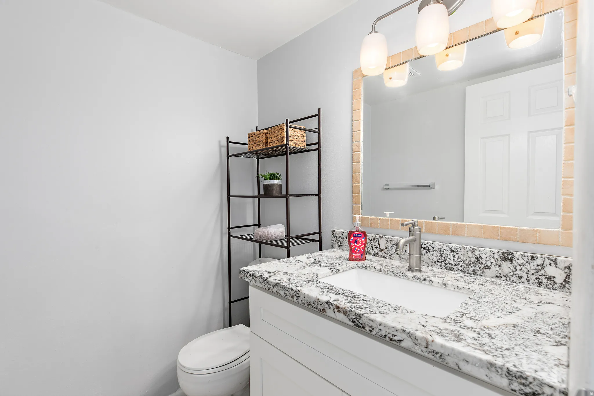 Bathroom featuring a vanity with a light granite countertop and an undermount sink