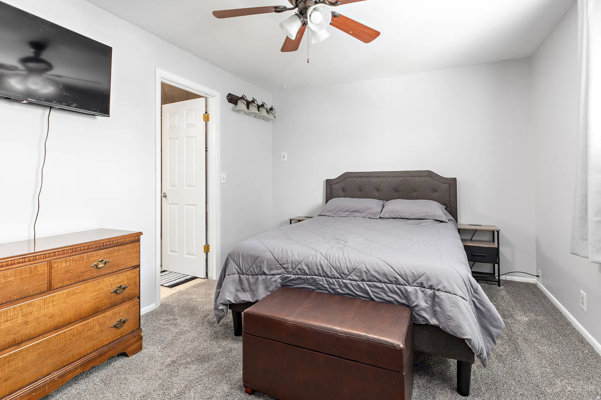Bedroom featuring light gray walls, gray carpet, and a ceiling fan with light fixture