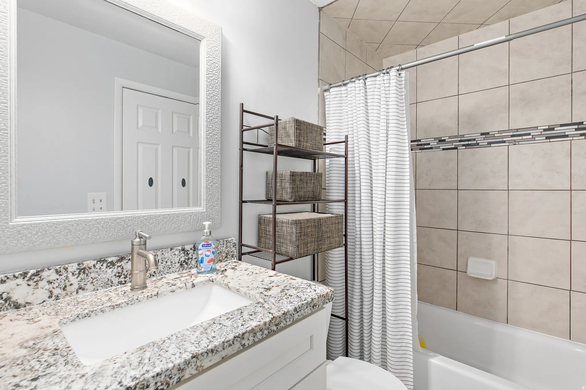 Bathroom featuring a white vanity with granite countertop and integrated rectangular sink