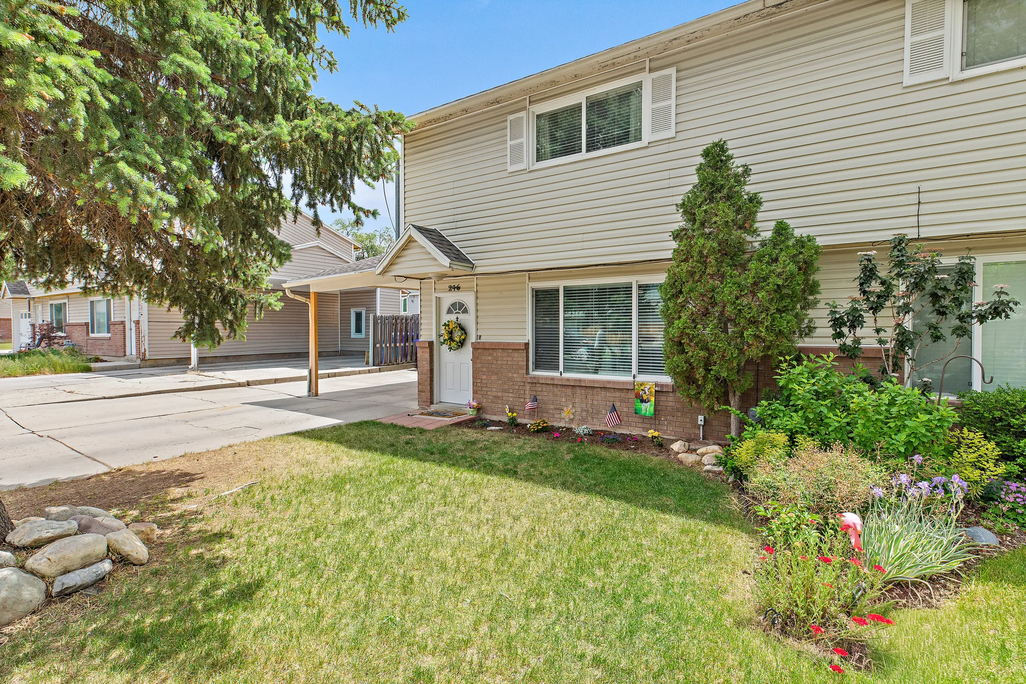 Exterior featuring horizontal siding, brick accents, a covered entry, and a carport