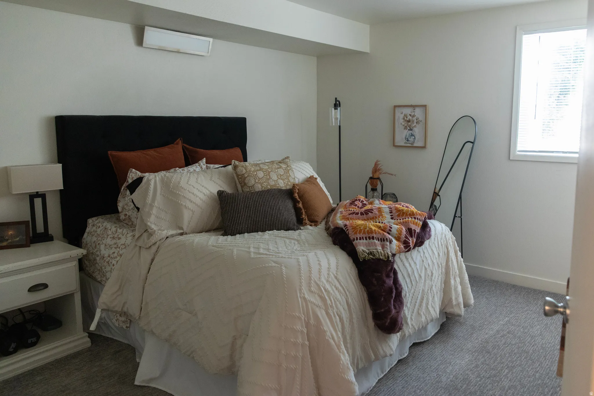 Neutral wall color with baseboard trim, carpet flooring, and a white-framed window