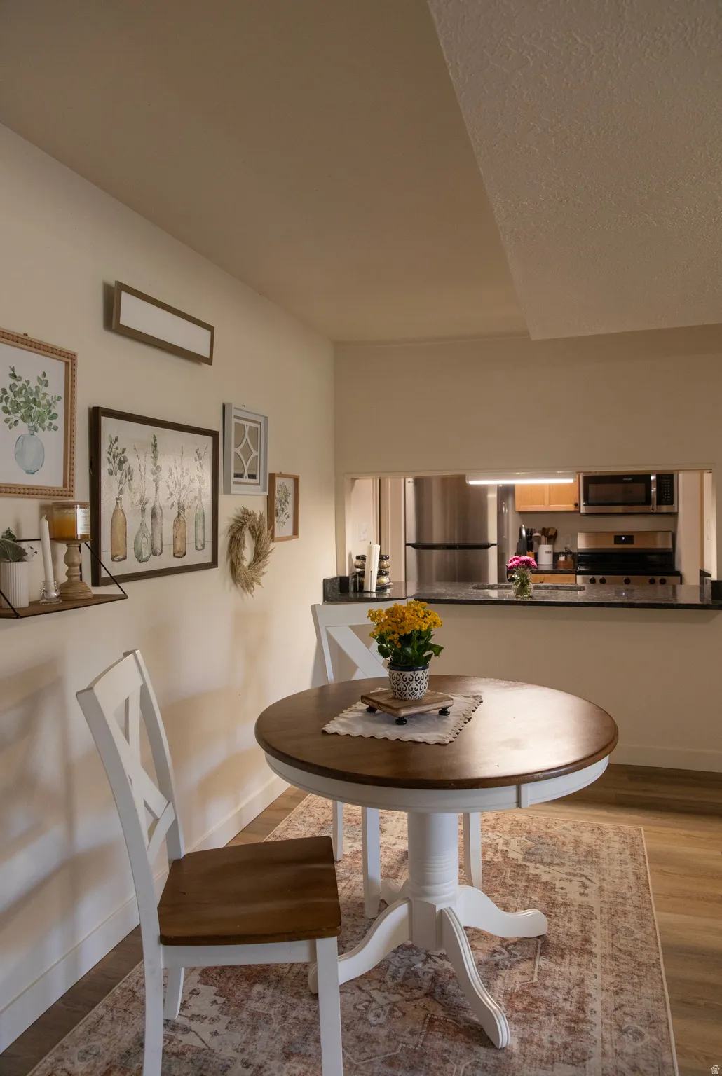 Dining area featuring wood-finish flooring and a pass-through opening to the kitchen