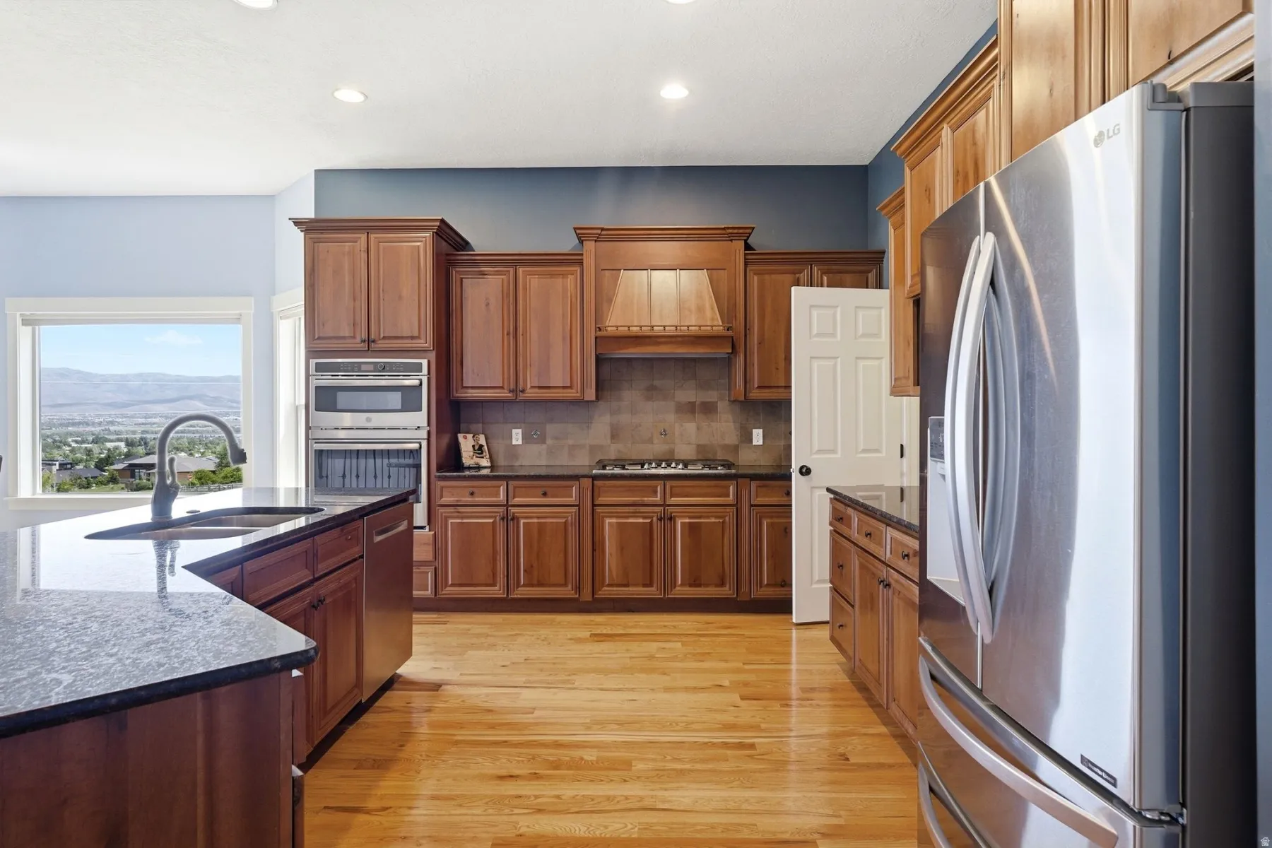 Kitchen featuring wood-finish cabinetry, dark countertops, and stainless steel appliances