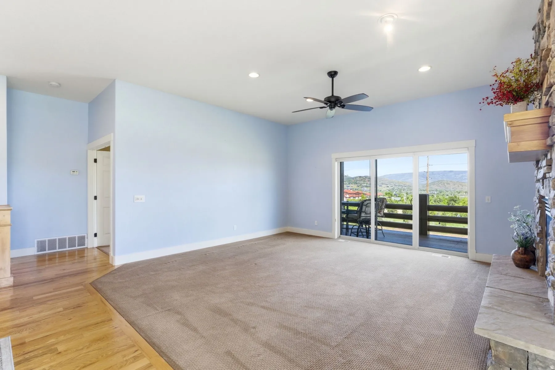 Spacious living area featuring light blue walls and a neutral carpet