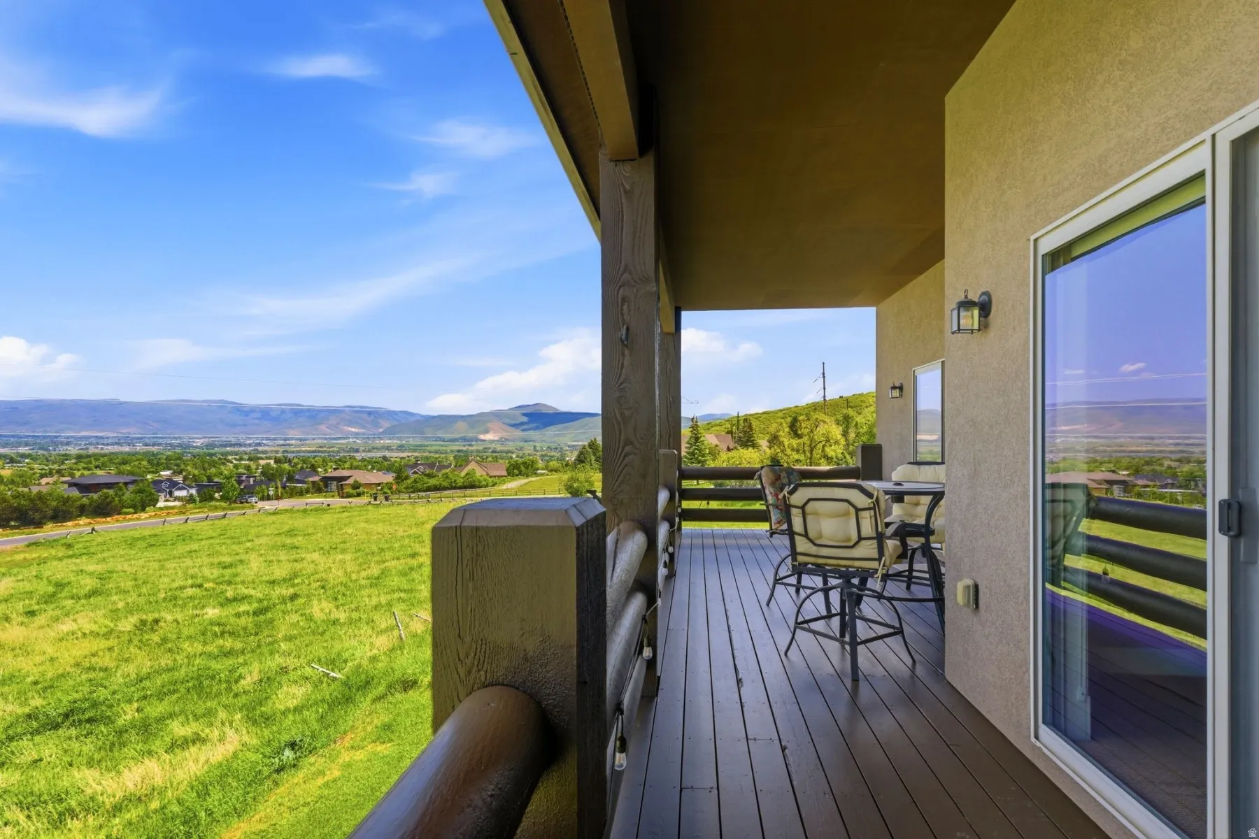 Spacious outdoor deck featuring dark wood-finish flooring and sturdy wood railings