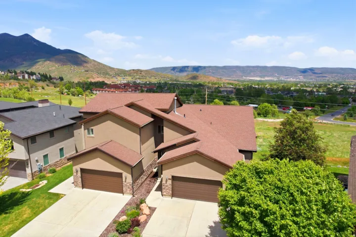 Multi-level residence featuring a stucco exterior and pitched roofing