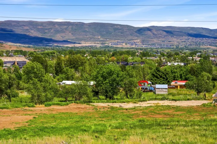 Expansive undeveloped land featuring a combination of green grass and exposed earth