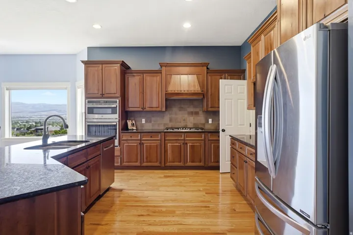 Kitchen featuring wood-finish cabinetry, dark countertops, and stainless steel appliances