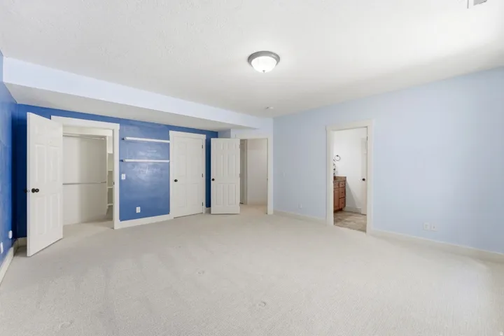 Spacious room with light-toned carpeting and contrasting blue walls