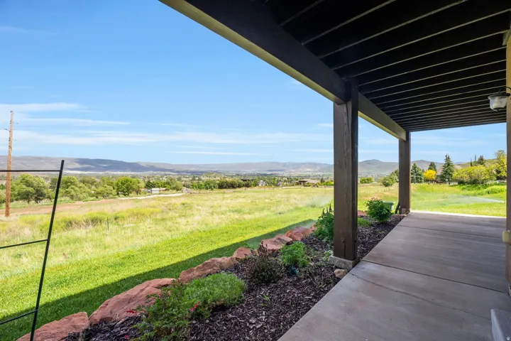 Expansive covered patio featuring a concrete surface and dark wood-tone support beams