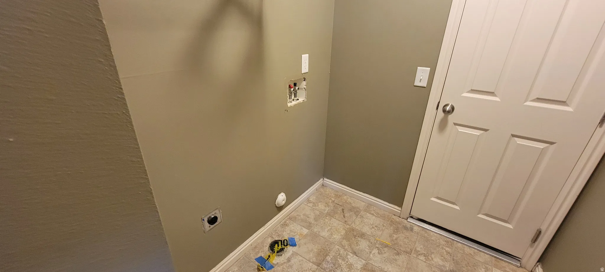 Functional utility space featuring neutral wall tones and a four-panel interior door