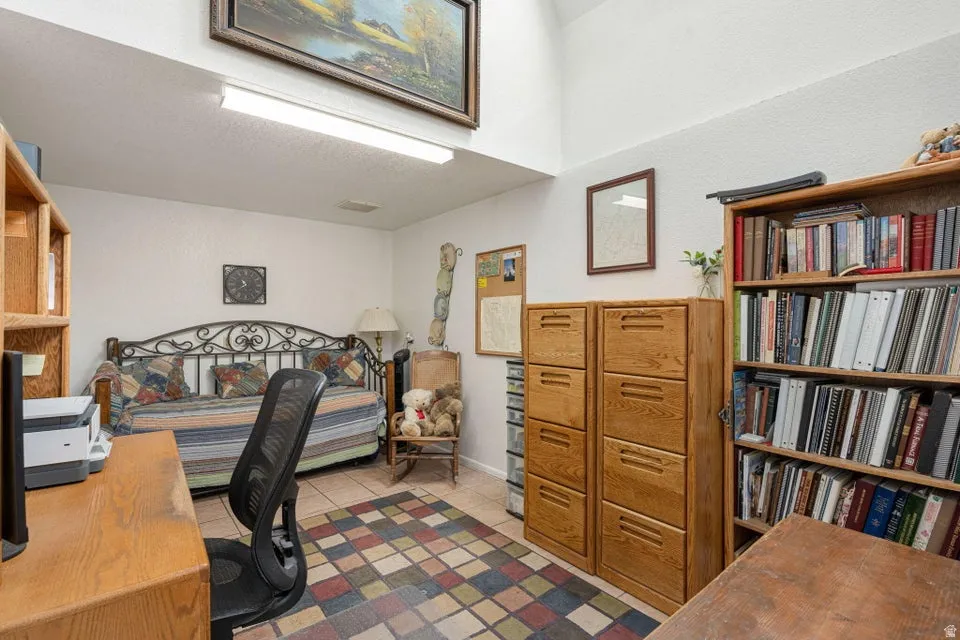 Room featuring high ceilings, tile flooring, and integrated overhead lighting