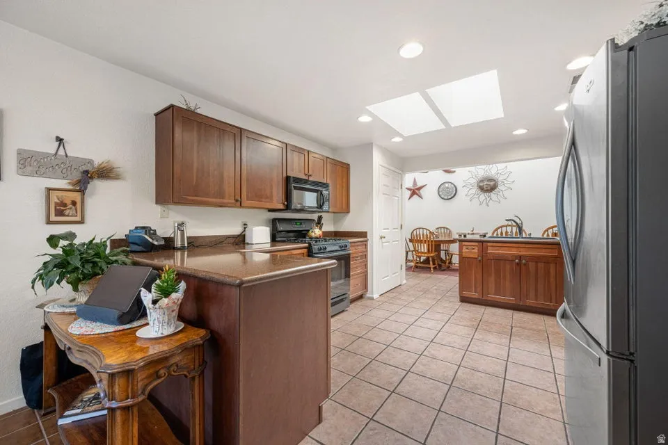 Kitchen featuring warm wood cabinetry, dark countertops, and stainless steel appliances