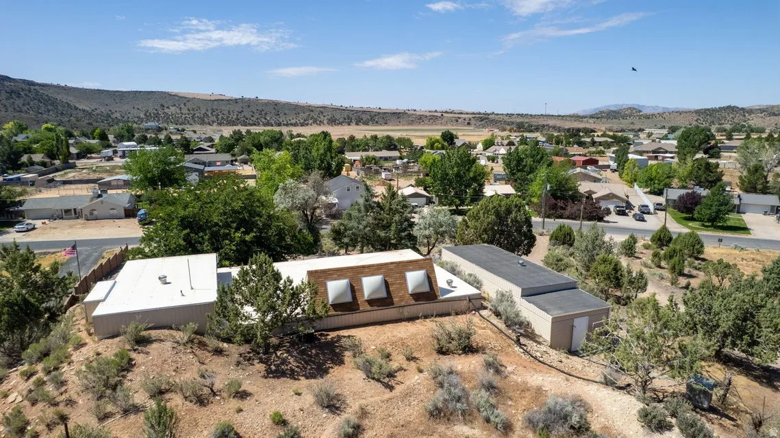 Property situated on a sloped landscape with sparse vegetation