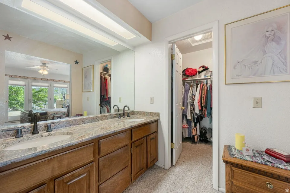 Double vanity featuring vessel sinks, stone countertops, and dark bronze fixtures