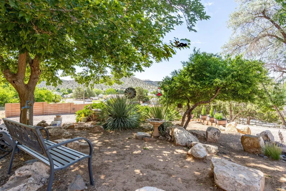 Rocky, arid landscaping featuring mature trees and various plantings