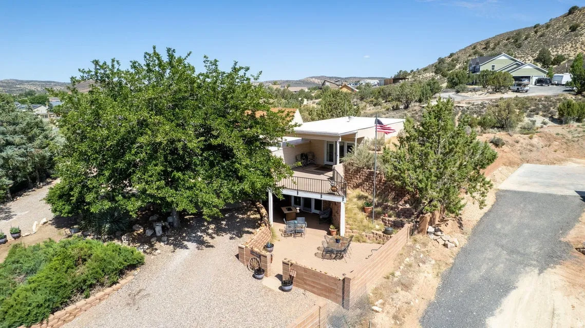 Terraced property with multiple outdoor living areas and a gravel driveway