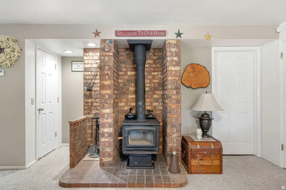 Brick fireplace surround featuring an integrated wood-burning stove and a raised hearth
