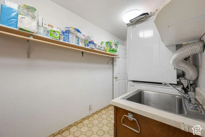 Laundry area featuring a utility sink, wood-finish cabinetry, and patterned vinyl flooring