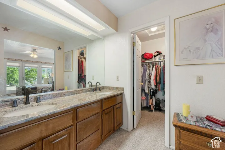 Double vanity featuring vessel sinks, stone countertops, and dark bronze fixtures