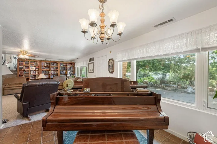 Spacious interior featuring a large window, tiled flooring, built-in shelving, and a ceiling fan