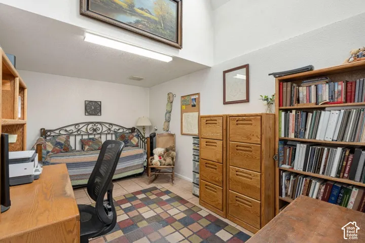 Room featuring high ceilings, tile flooring, and integrated overhead lighting