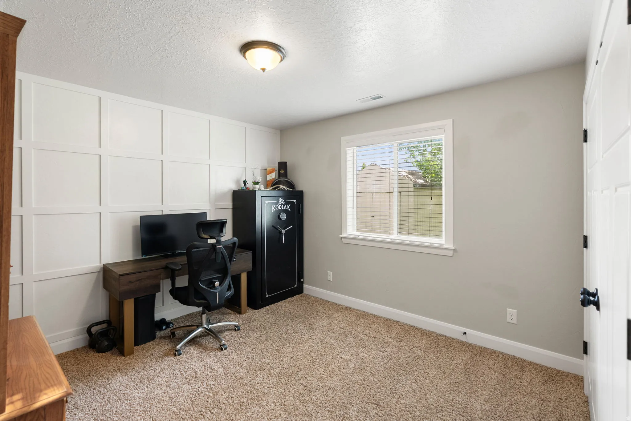 Bedroom featuring a white board and batten accent wall, neutral wall paint, and plush carpet flooring