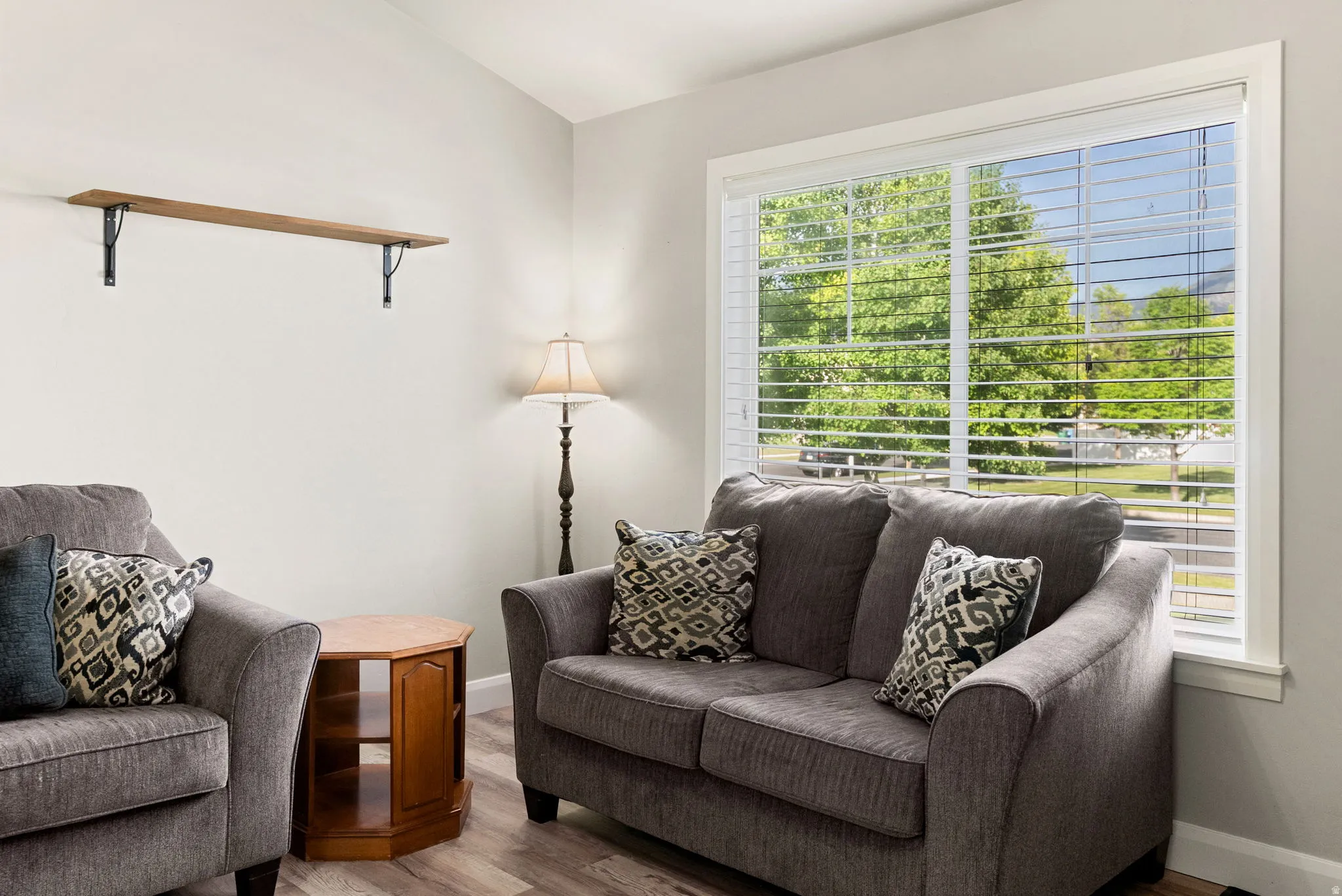 Bright living area featuring a large window with white blinds