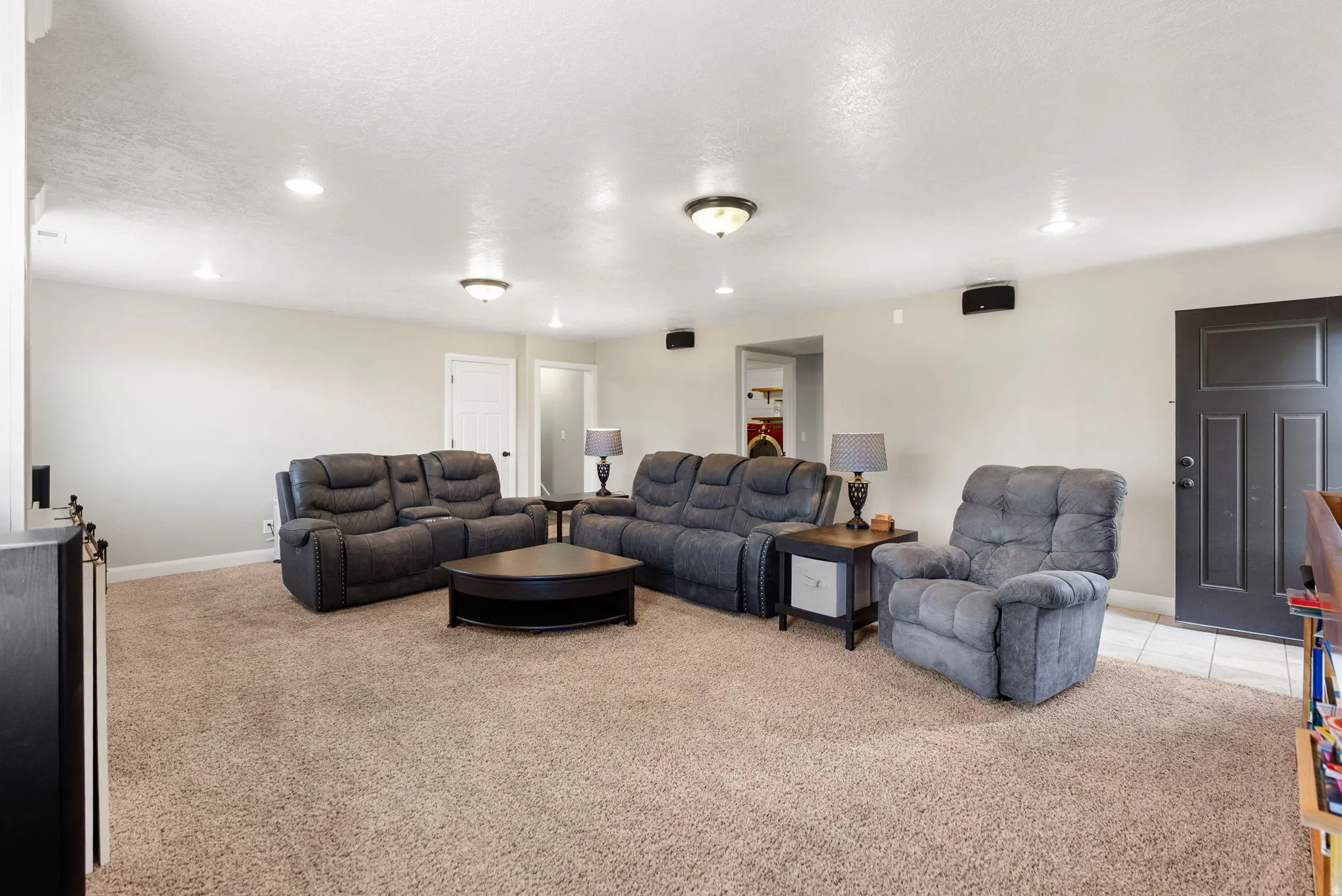 Spacious living area featuring neutral-toned carpeting, recessed lighting, and light-colored walls