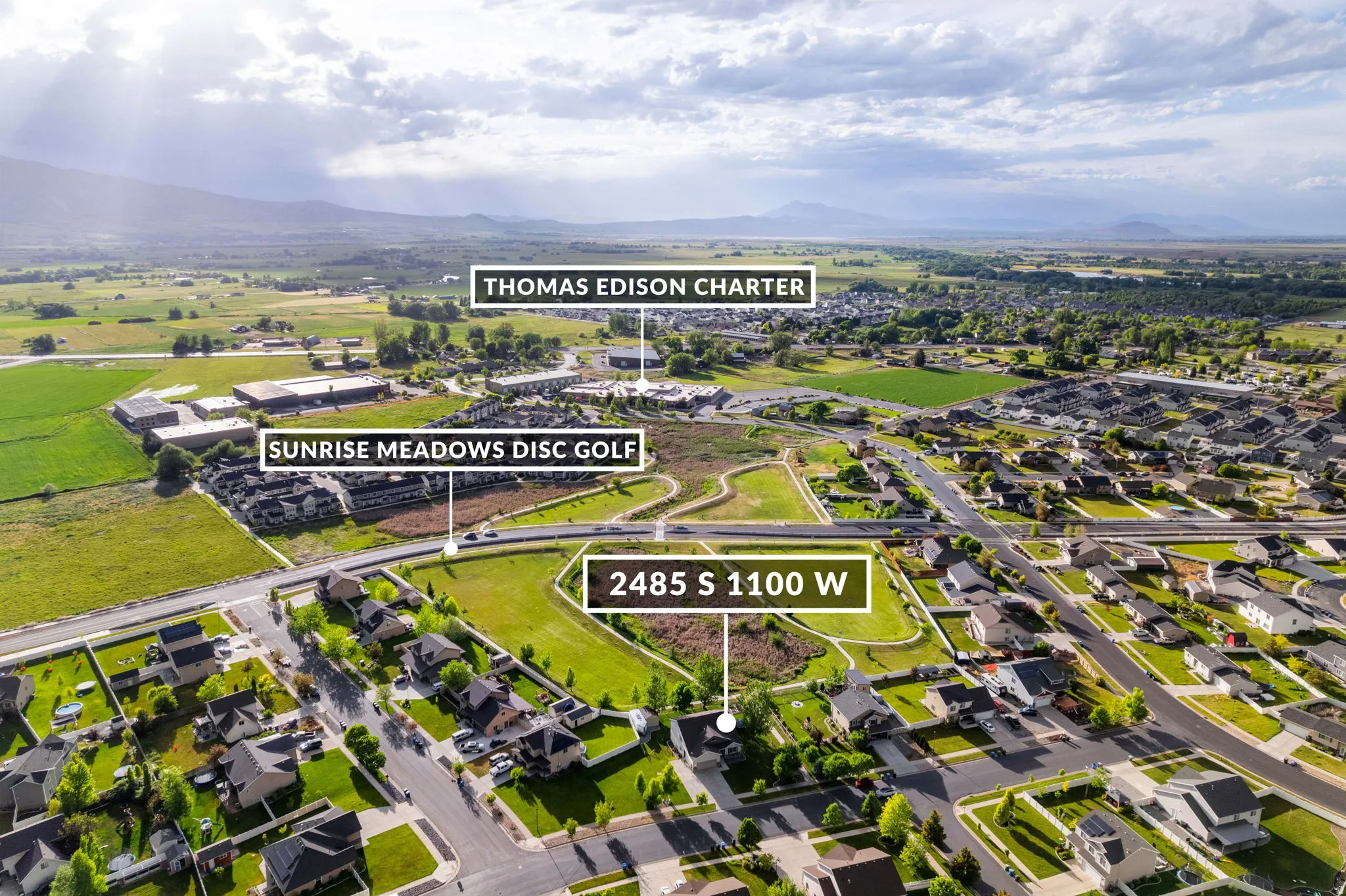 Aerial view showcasing residential areas, green spaces, and mountain backdrops