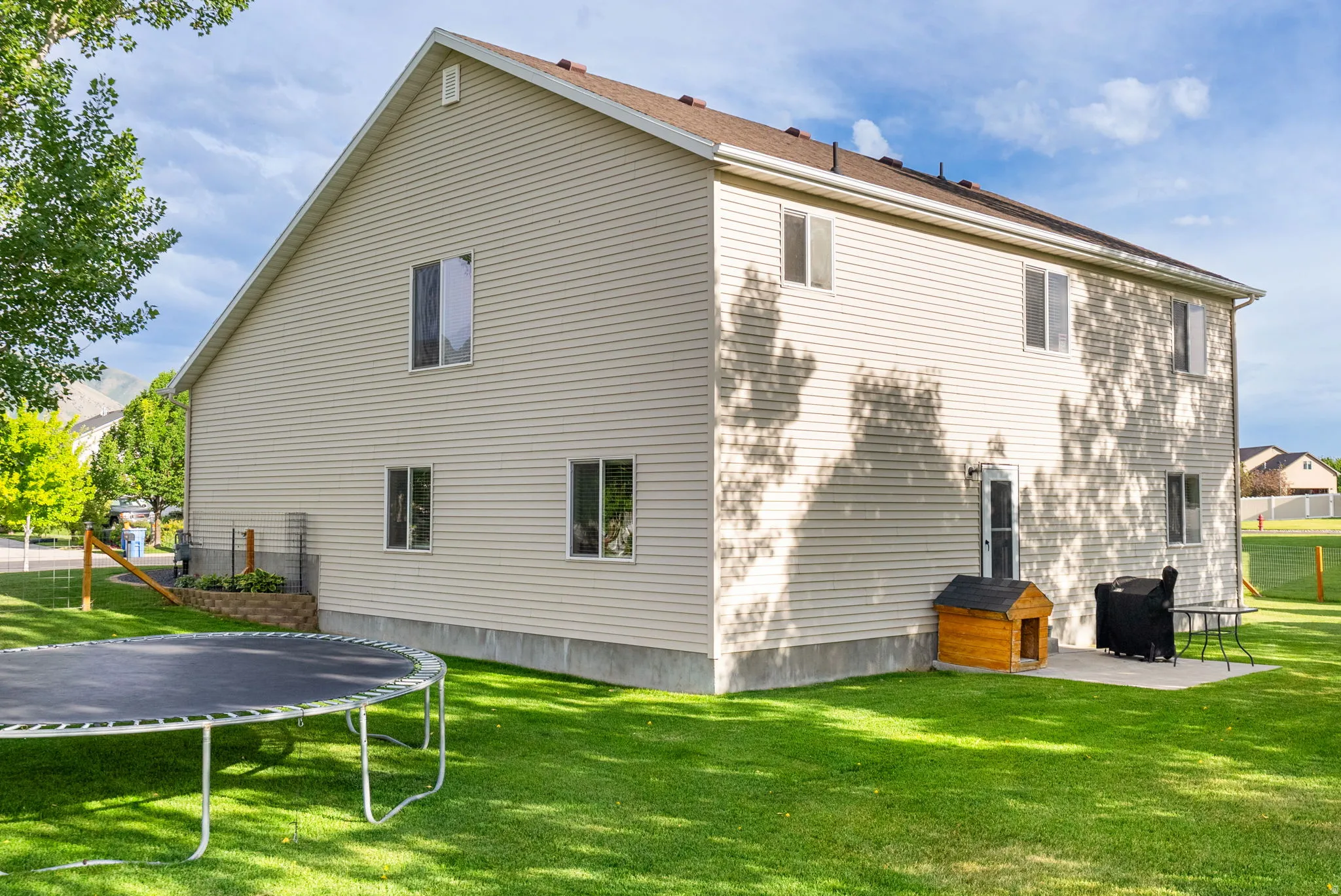 Cream-colored siding exterior featuring multiple windows and a brown shingle roof