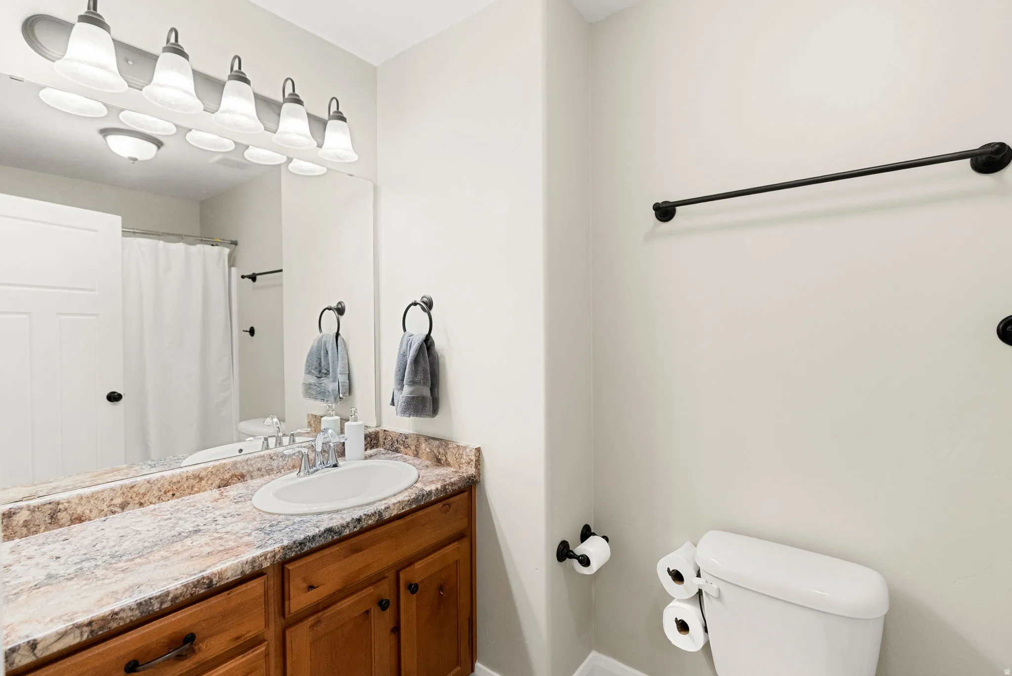 Bathroom vanity with a light wood-finish cabinet and a patterned countertop