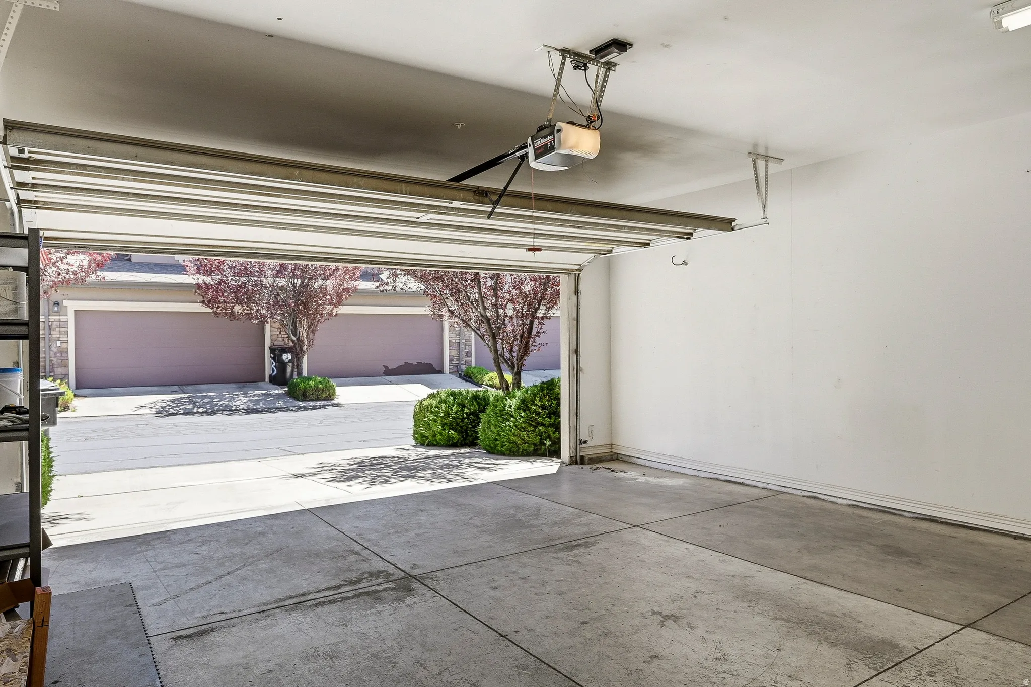 Spacious garage with concrete flooring and an automatic overhead door opener